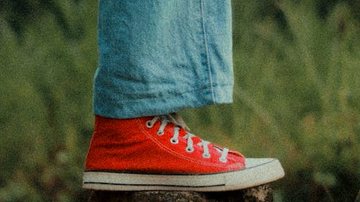 Pessoa com tênis vermelho e calça jeans azul - Pexels