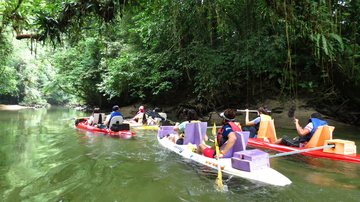 Canoagem no rio Jaguareguava é opção com águas cristalinas #pratodosverem Foto colorida. Um grupo com canoas adaptadas, com apoios, navega em águas cristalinas, que refletem o verde das árvores do entorno - Divulgação/Jaguareguava Ecoturismo