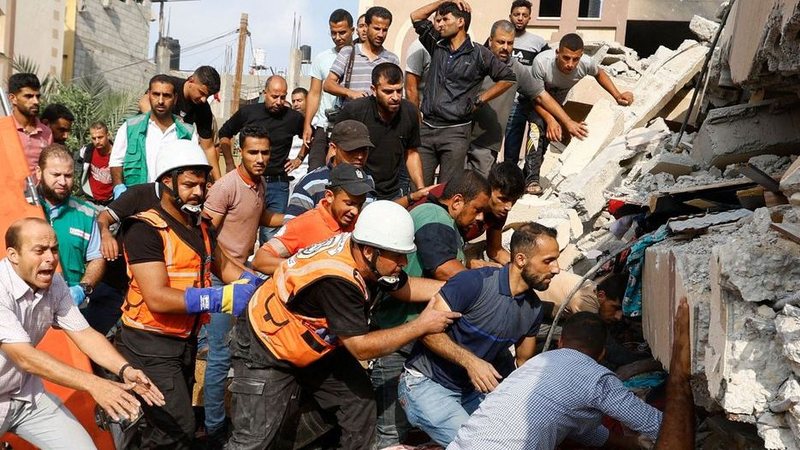 Palestinos vasculham escombros após missil atingir um imóvel - Agência Brasil