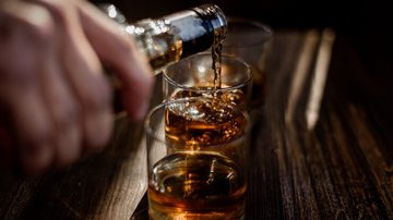 Enchendo copo de whisky - Freepik