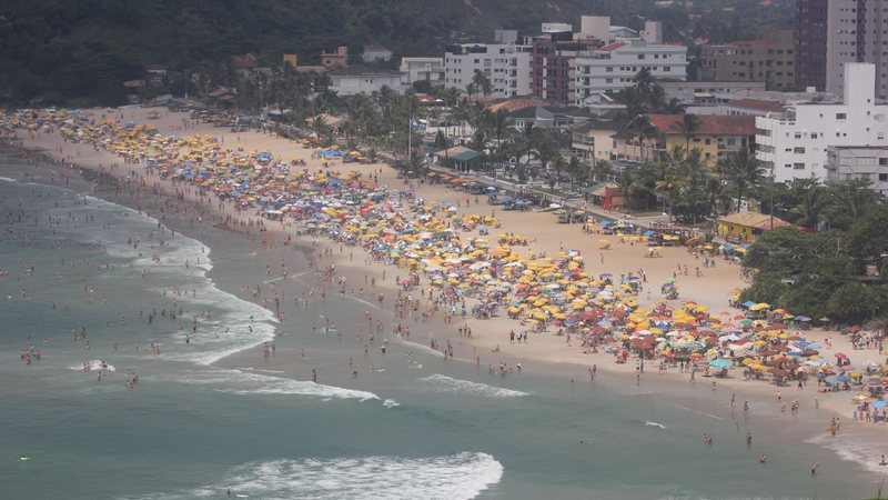Praia do Tombo, em Guarujá. Ocupação de hospedagens pode atingir patamar histórico - Imagem: Reprodução / Pedro Rezende