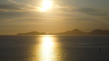 Ao amanhecer, os termôetros já marcavam 29,8 graus em Santos! Santos registra sensação térmica de quase 50 graus neste domingo Pessoa tirando foto como se estivesse segurando o sol nascendo - Carlos Nogueira/PMS