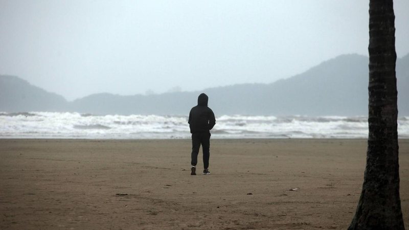 Pessoa agasalhada na praia