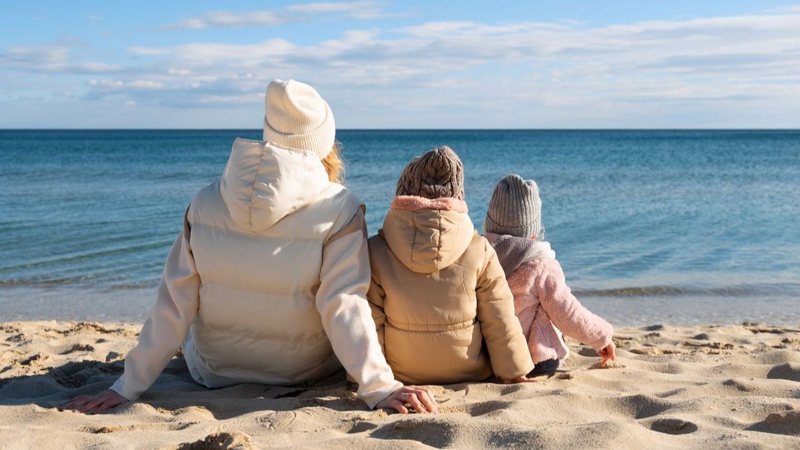 Família agasalhada na praia