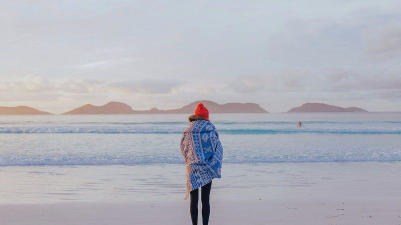 Mulher agasalhada na praia