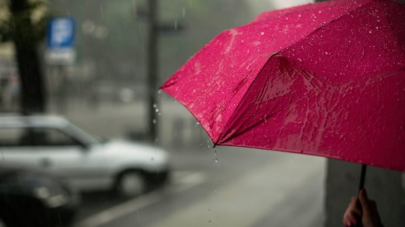 Pessoa com gurada-chuva vermelho