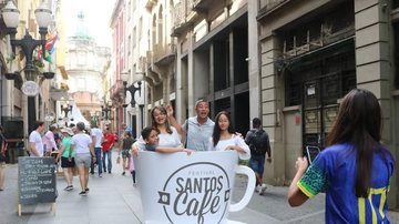 Pessoas posando para fotos na xícara do Festival Santos Café