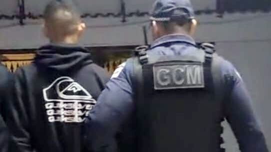 Um dos adolescentes envolvidos no crime é conduzido à delegacia pela GCM - Prefeitura de Caraguatatuba