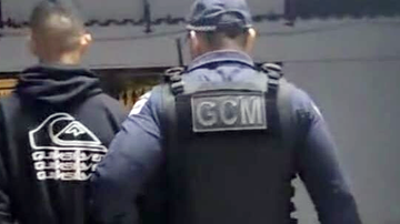 Um dos adolescentes envolvidos no crime é conduzido à delegacia pela GCM - Prefeitura de Caraguatatuba