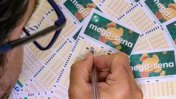 Pessoa preenchendo volantes da Mega-Sena