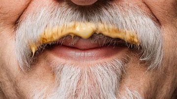 Homem de bigode grisalho sujo de molho