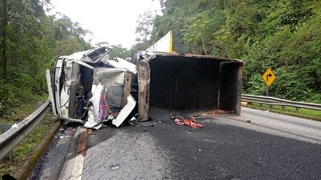 Caminhão carregado de asfalto tomba ao descer a serra e interdita rodovia Mogi-Bertioga