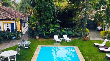 A Piscina aquecida da Pousada Vila Brasil, com jardim e natureza em seu entorno