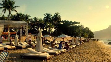 Foto de um beach club com piscina, espreguiçadeiras, deque e vista para o mar