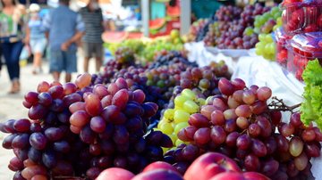 Banca de feira livre em Itanhaém com frutas, verduras, carnes e artesanatos