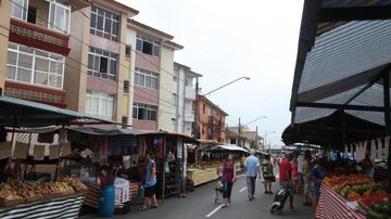 Feira livre em Santos com barracas de frutas, legumes e verduras montadas em rua residencial