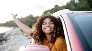Mulher feliz enquanto viaja de carro