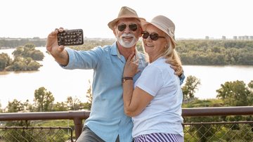 Casal de idosos tira foto em ponto turístico durante viagem gratuita com conforto e segurança