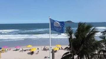 Praia do tombo, no Guarujá, com fortes ondas e a bandeira azul hasteada