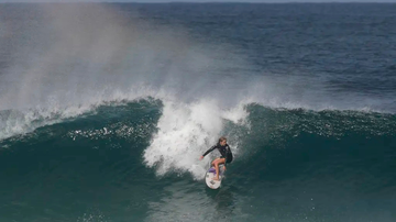 Pessoas surfando uma onda no mar