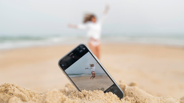 Celular na areia com a câmera ligada