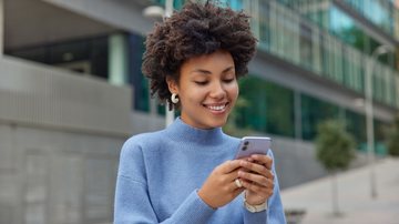 Pessoa utiliza a internet do celular em área pública