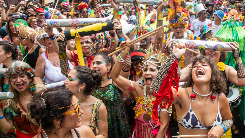 Pessoas com maquiagens e fantasias comemorando carnaval