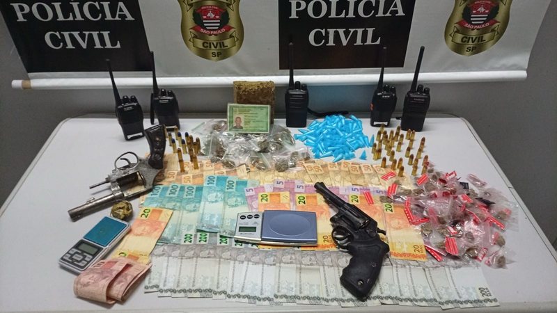 Itens apreendidos pela Polícia Civil, incluindo dinheiro, porções de drogas e armas