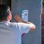 Imagem de um homem de costas com a mão em um muro