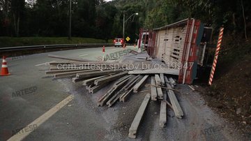 Caminhão tombado na rodovia dos Tamoios, com carga derramada sobre a via