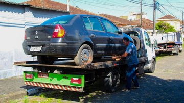 Carro abandonado em cima de guincho, em rua de São Vicente