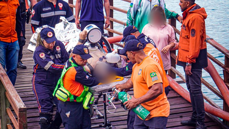 Agentes realizando processo de ressuscitação em vítima do naufrágio