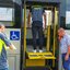 Imagem de um fiscal de trânsito em cima de um elevador para cadeirantes de um ônibus