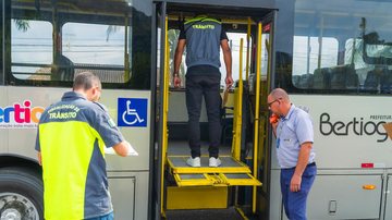 Imagem de um fiscal de trânsito em cima de um elevador para cadeirantes de um ônibus