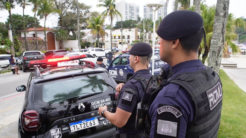 Agentes da Romu, próximos de viaturas, de costas para a praia