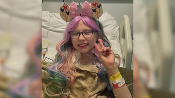 Uma garotinha com peruca colorida e uma tiara da Disney