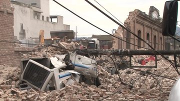 Trator retirando os escombros do muro desabado