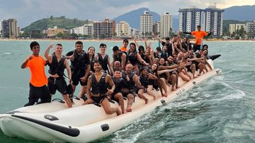 Imagem mostra um grupo animado de pessoas em passeio de banana boat gigante em Caraguatatuba, no litoral norte de São Paulo.
