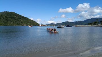 Imagem de pessoas remando em canoa no Canal de Bertioga