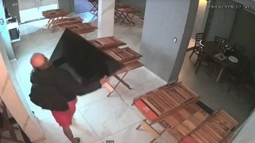 A imagem de câmara de segurança mostra um homem furtando uma televisão de uma pizzaria pertencente ao ex-jogador Alex Willian