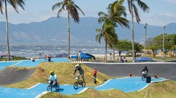 pista de bicicross com algumas pessoas de bicicleta praticando o esporte