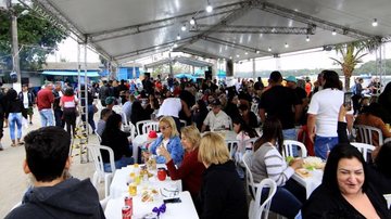 Imagem de várias pessoas sentadas em cadeiras, abaixo de uma tenda, no evento na Ilha Diana