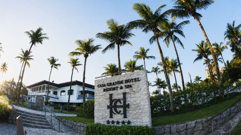 Fachada do Casa Grande Hotel Resort & Spa, cercada por palmeiras, jardins e áreas verdes