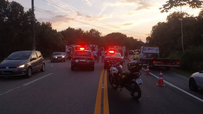 A imagem mostra um acidente grave na SP-55 (Rodovia Rio-Santos), no trecho de Boraceia, envolvendo uma colisão entre um carro e uma moto