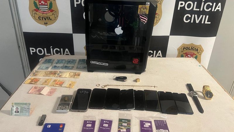 Imagem de diversos produtos apreendidos: computador, celulares, relógios, dinheiro, entre outros
