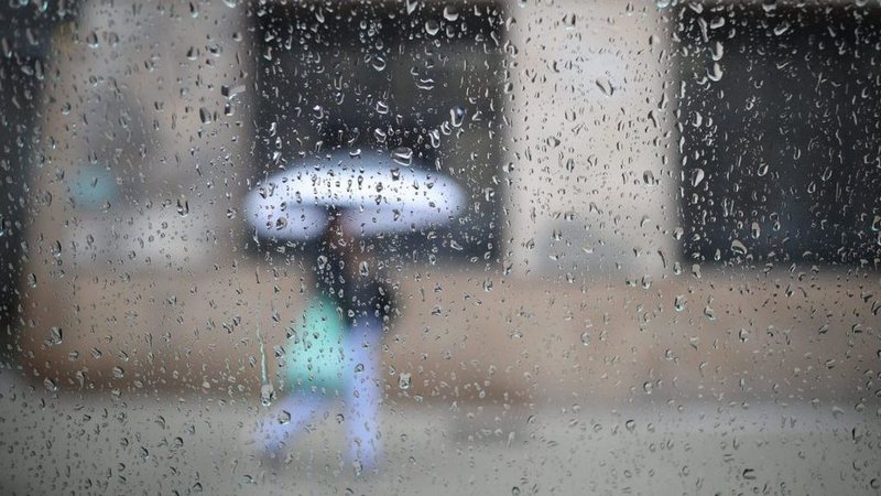 Pessoa com guarda chuva em tempestade