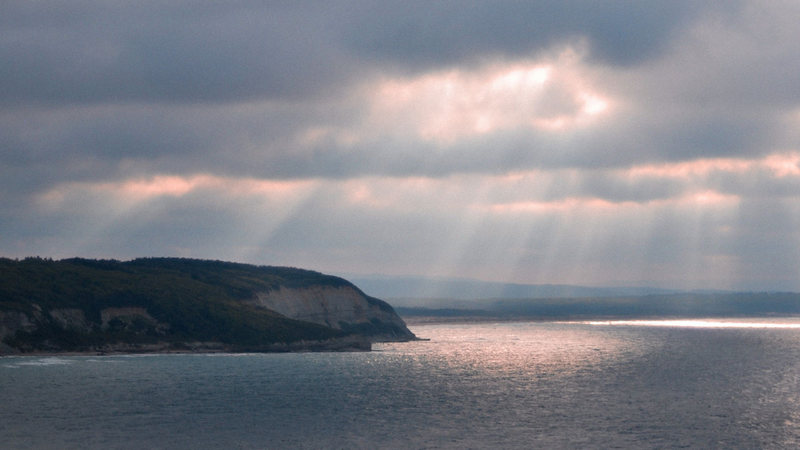 Sol entre nuvens no litoral