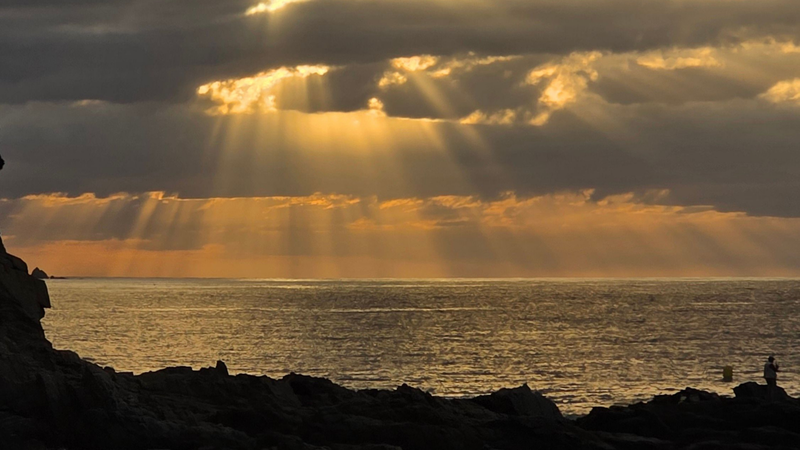 Sol entre nuvens no litoral
