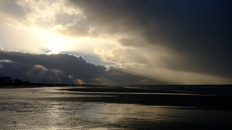 Sol entre nuvens no litoral