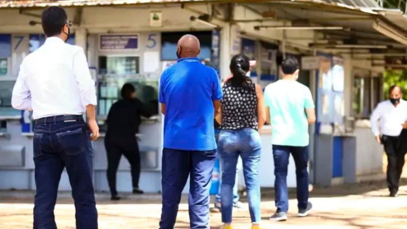 Pessoas esperando em fila de lotérica